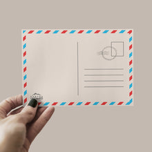 Charger l'image dans la galerie, a hand holding a postcard with a stamp on it